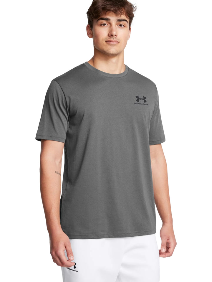 Hombre vistiendo una camiseta deportiva de color gris de manga corta con logo de Under Armour en el pecho.