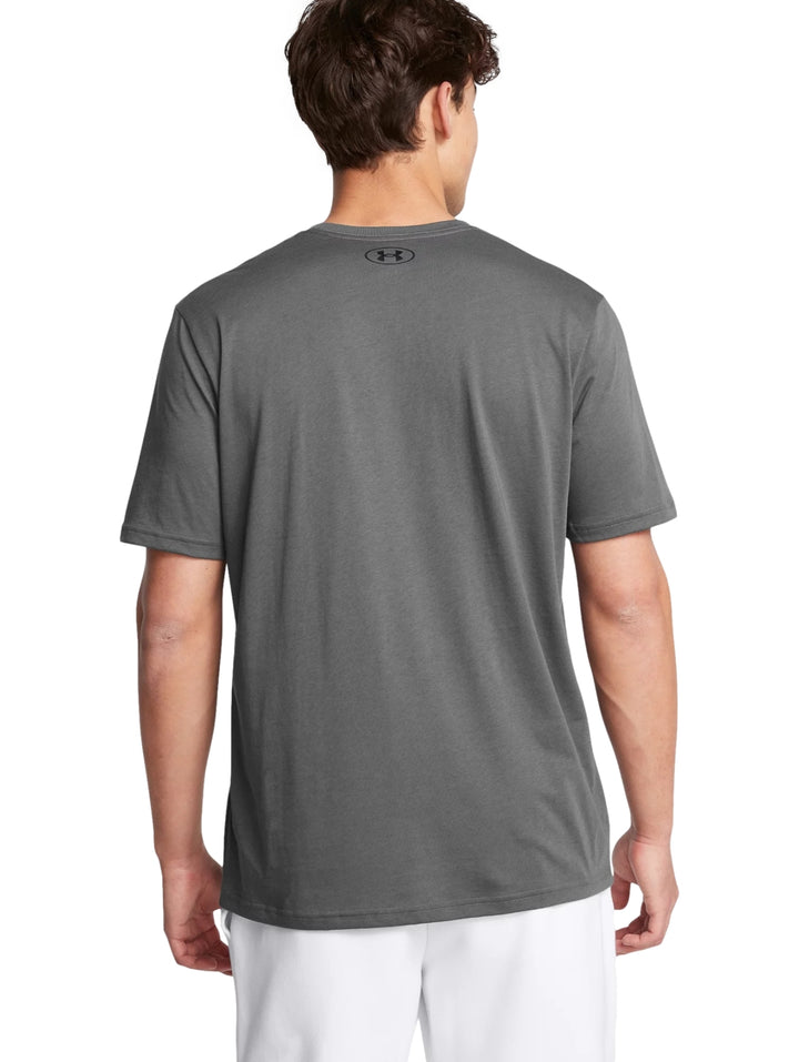 Hombre vistiendo una camiseta deportiva de color gris de manga corta con logo de Under Armour en el pecho.