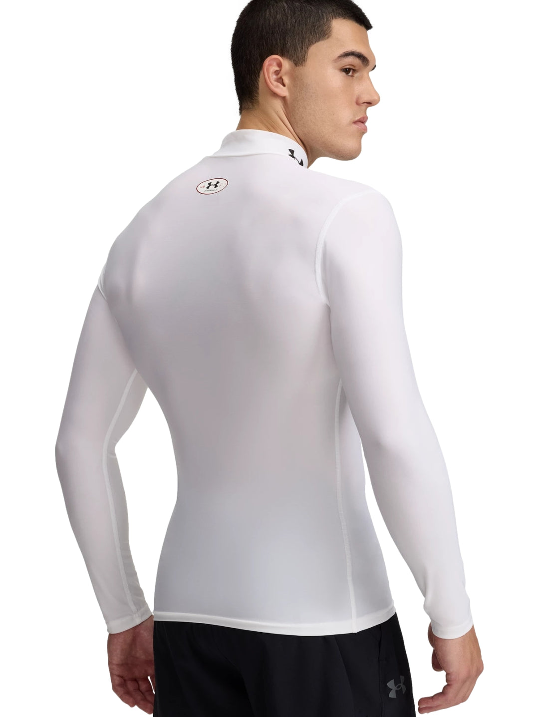 Camiseta de compresión blanca de manga larga y cuello mock marca Under Armour.