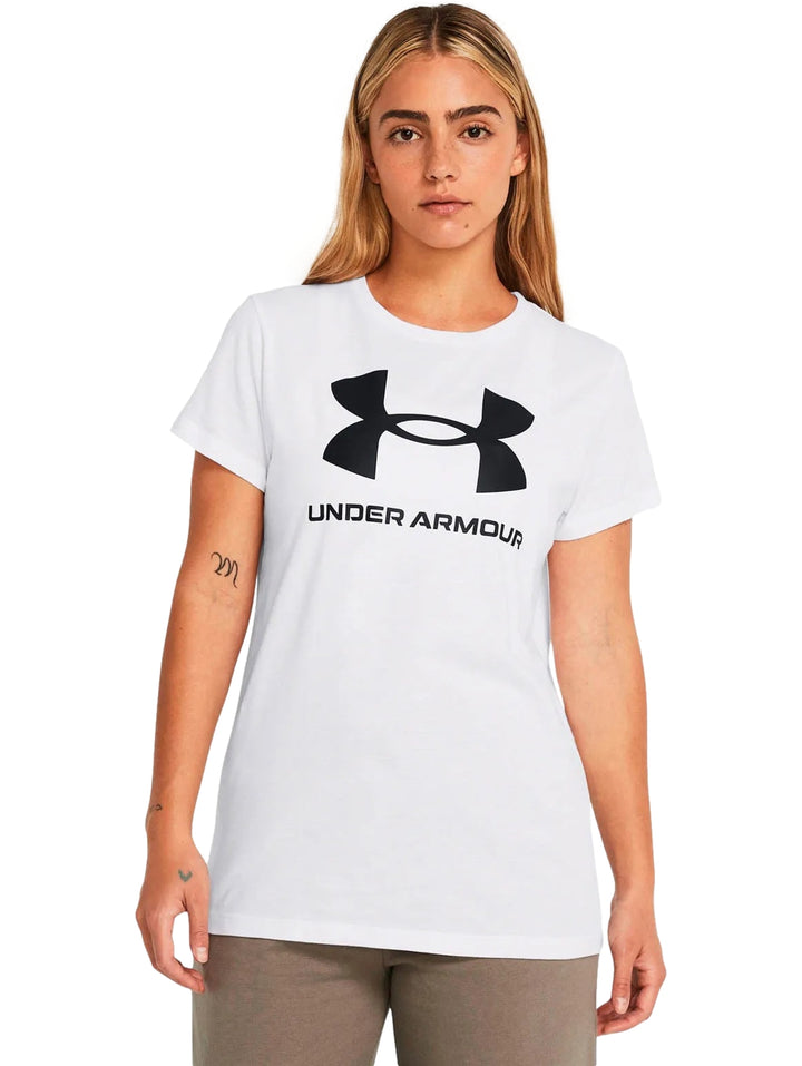 Mujer vistiendo una camiseta blanca de manga corta con el logo de Under Armour en color negro en el pecho.