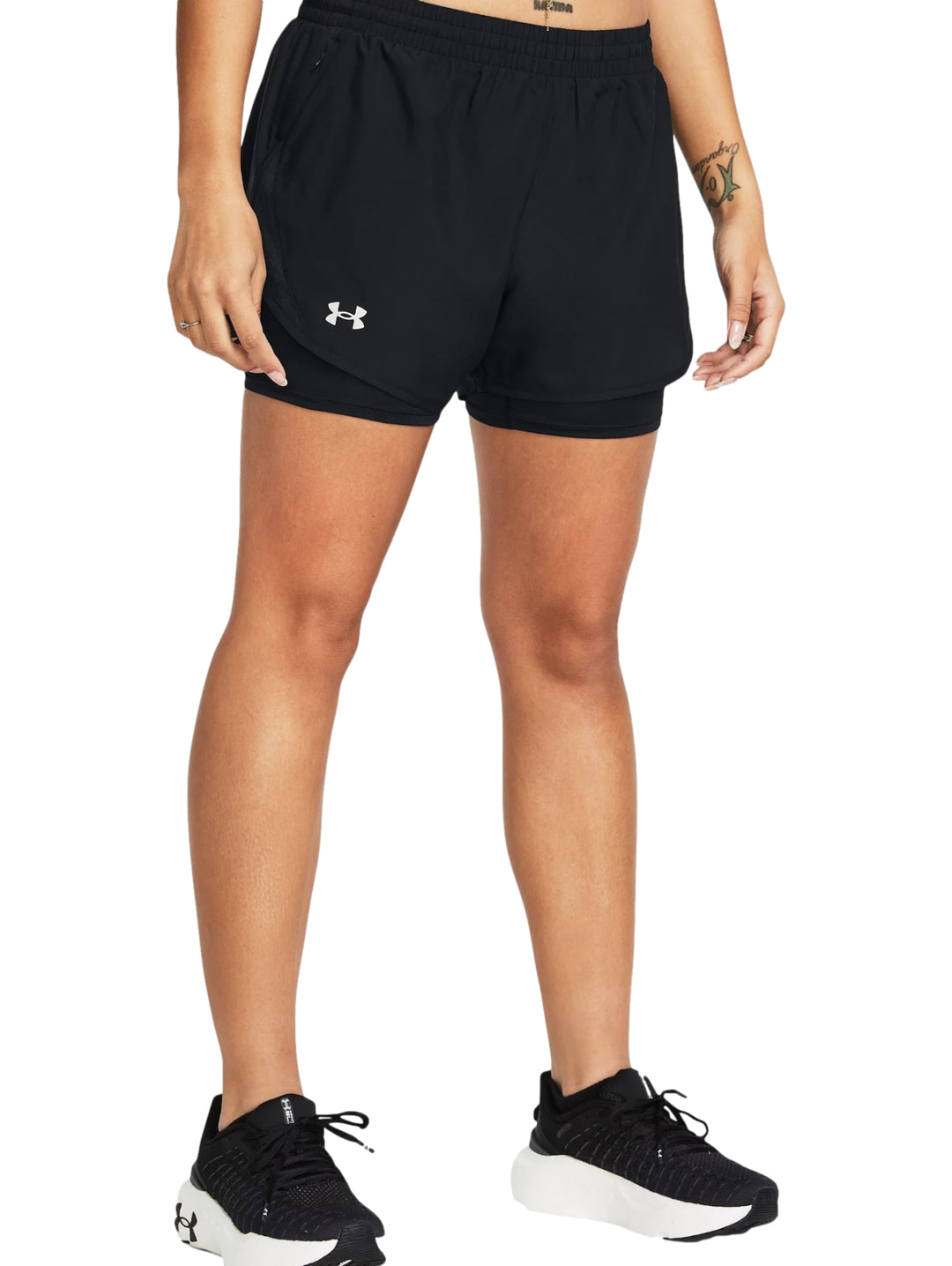 Mujer vistiendo shorts deportivos Under Armour color negro, modelo 2 en 1.