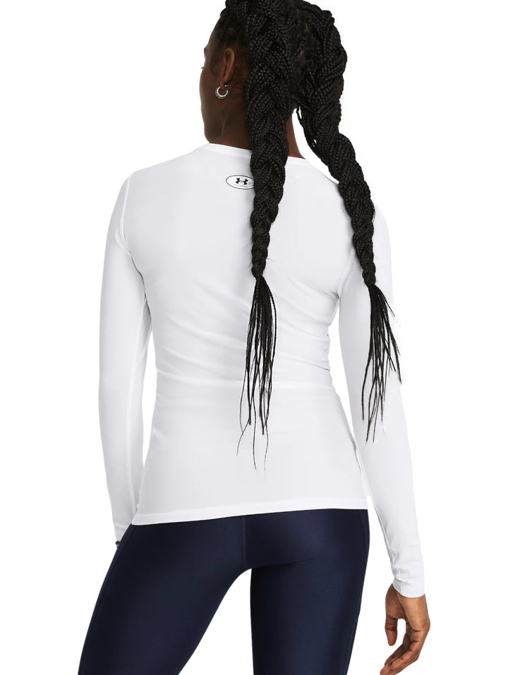 Mujer vistiendo una camiseta deportiva de compresión blanca de manga larga de Under Armour.