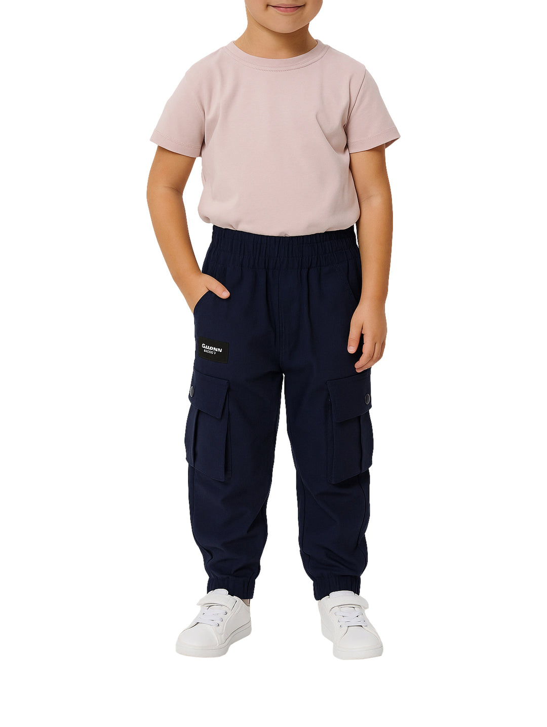 Niño vistiendo pantalón cargo color marino con bolsillos laterales y tenis blancos.