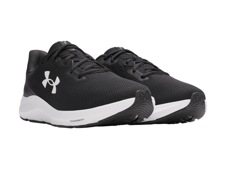 Tenis deportivos Under Armour color negro con suela blanca y logotipo blanco en el costado.