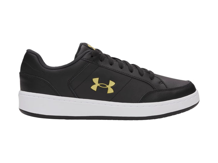 Tenis Under Armour color negro con suela blanca y logotipo dorado en el lateral.