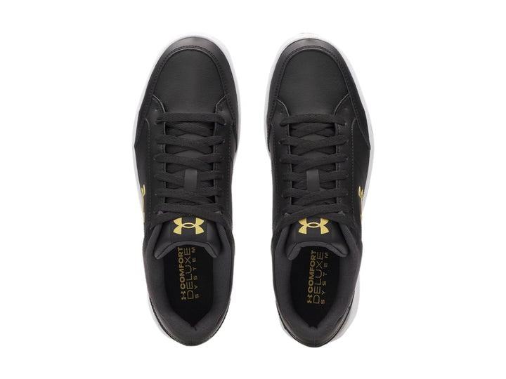 Tenis Under Armour color negro con suela blanca y logotipo dorado en el lateral.