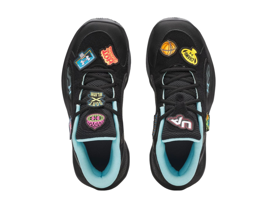 Tenis de baloncesto Under Armour color negro con detalles en azul claro y parches decorativos.