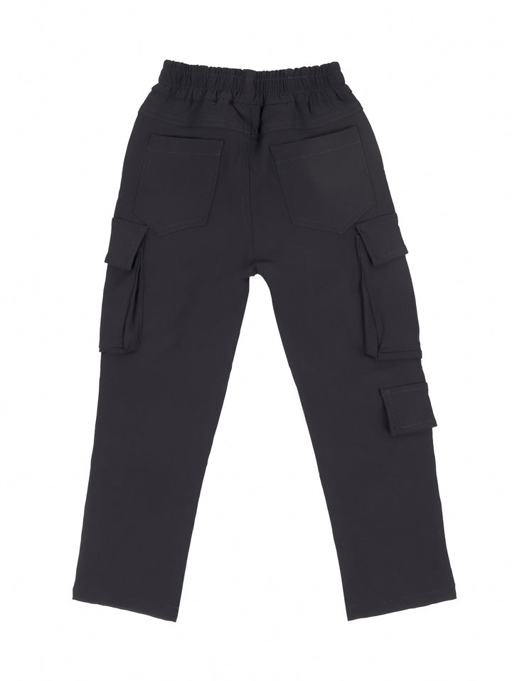 Niño vistiendo pantalón cargo color gris oscuro con bolsillos laterales y camiseta blanca.