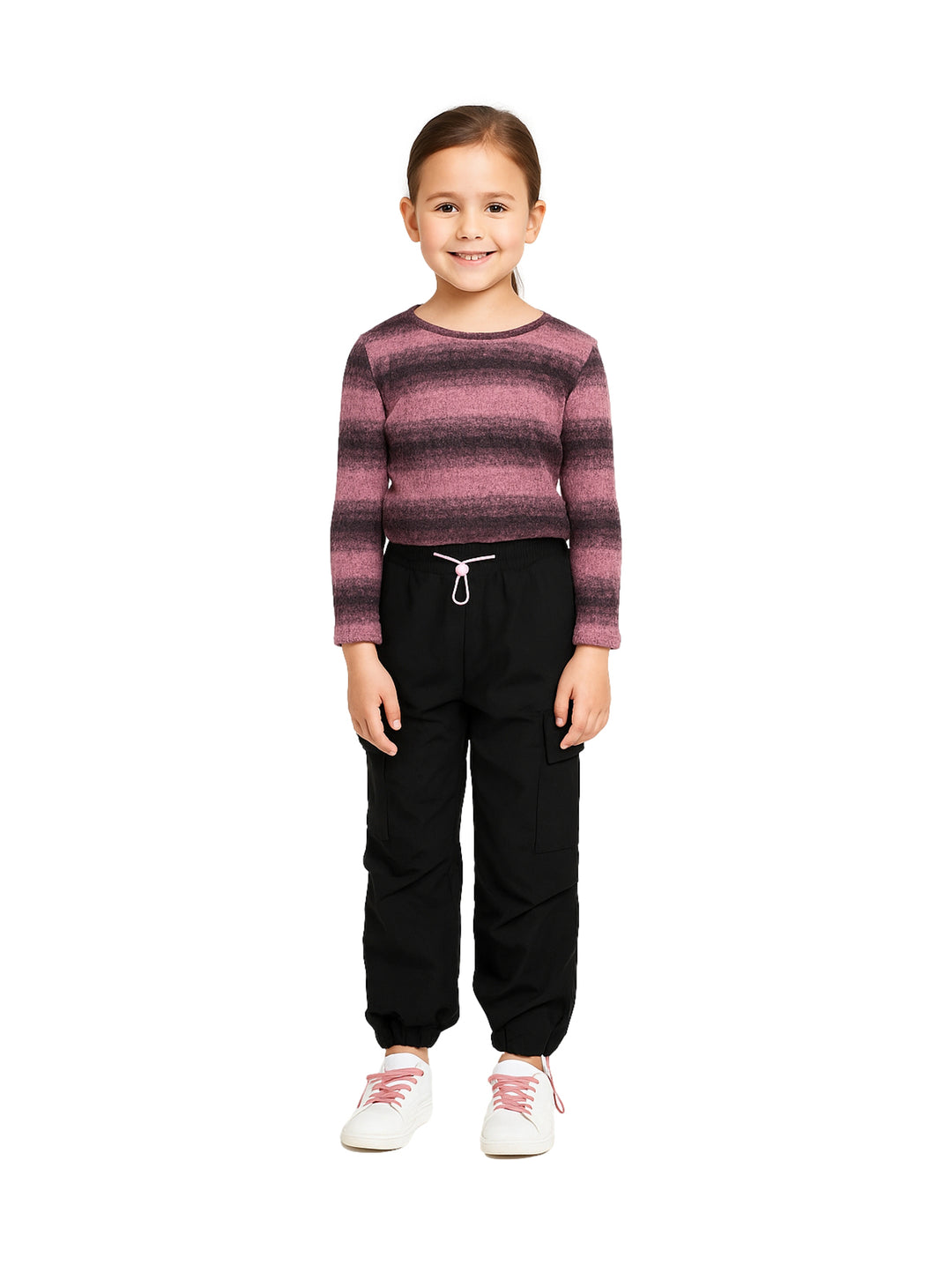 Niña vistiendo conjunto de camiseta rosa a rayas y pantalón cargo negro con tenis blancos.