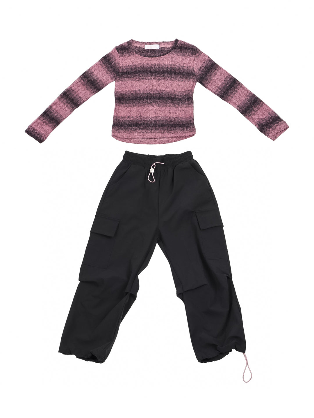 Niña vistiendo conjunto de camiseta rosa a rayas y pantalón cargo negro con tenis blancos.