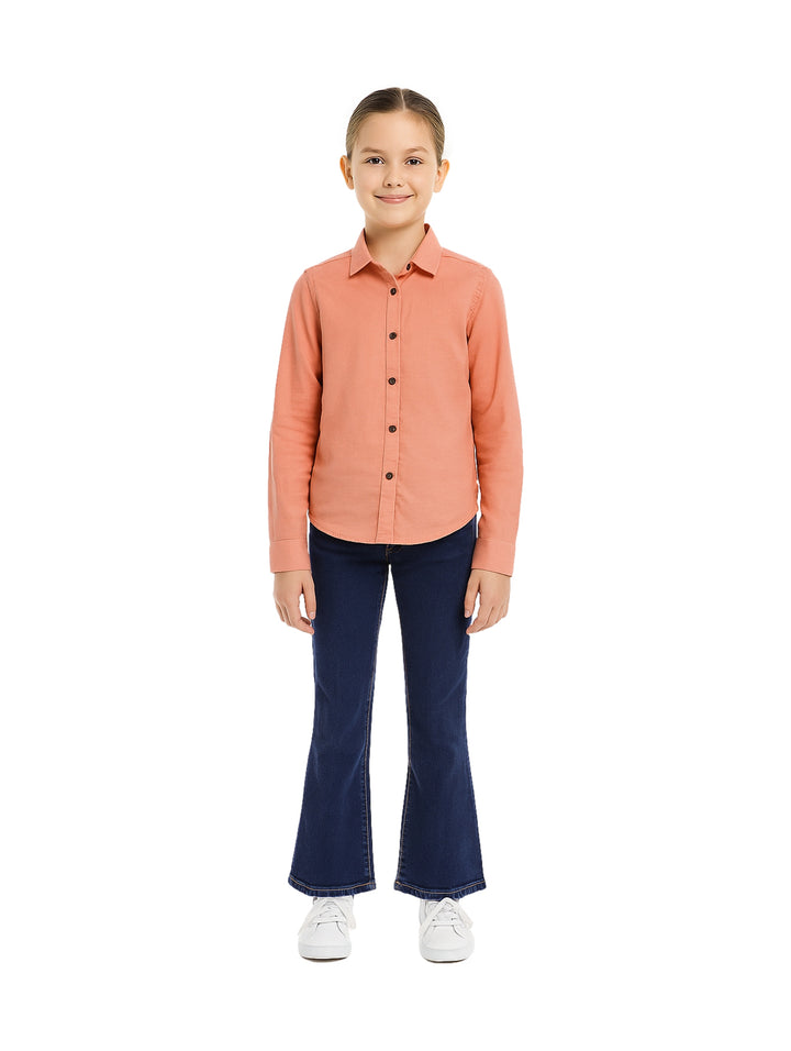 Niña vistiendo un conjunto de camisa color palo de rosa y pantalones azul marino acampanados.