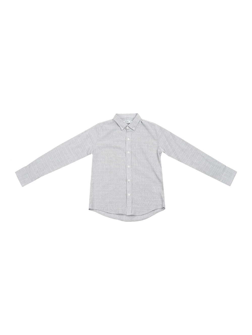 Niño vistiendo una camisa gris de manga larga con botones y pantalones azul marino.