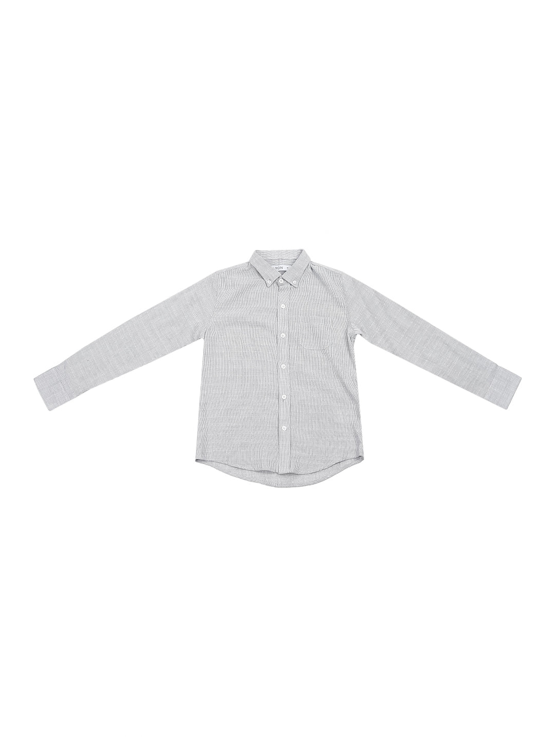 Niño vistiendo una camisa gris de manga larga con botones y pantalones azul marino.