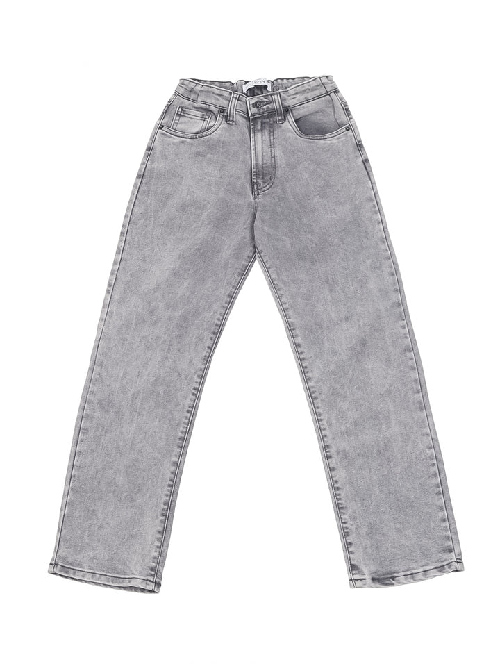 Niño vistiendo un pantalón vaquero color gris de corte recto y camiseta blanca.