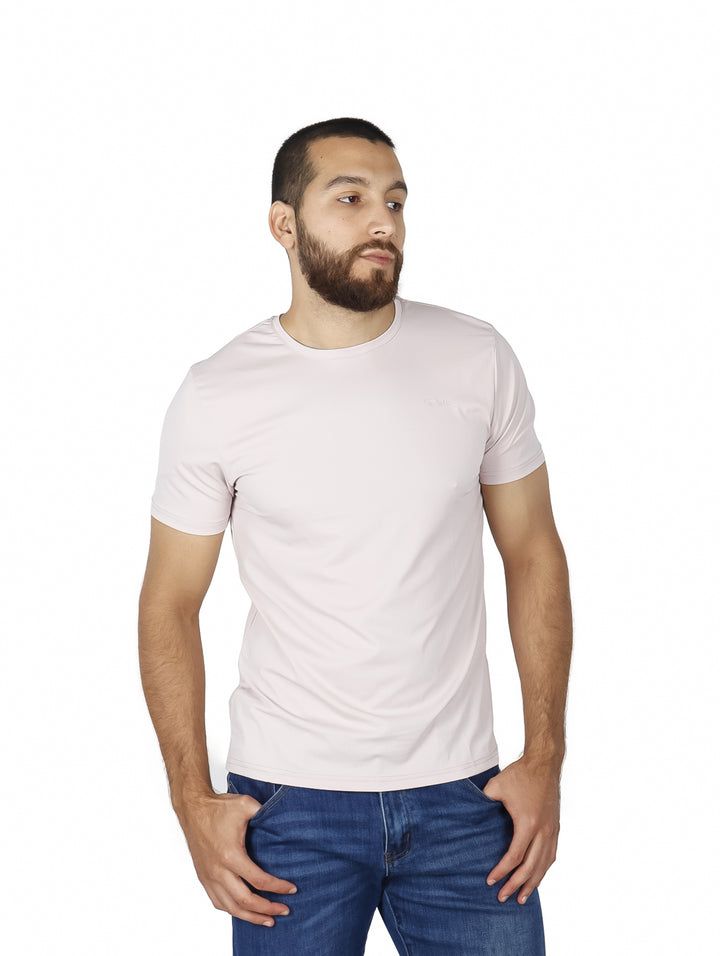 Hombre vistiendo una playera básica de color rosa claro con cuello redondo y manga corta.