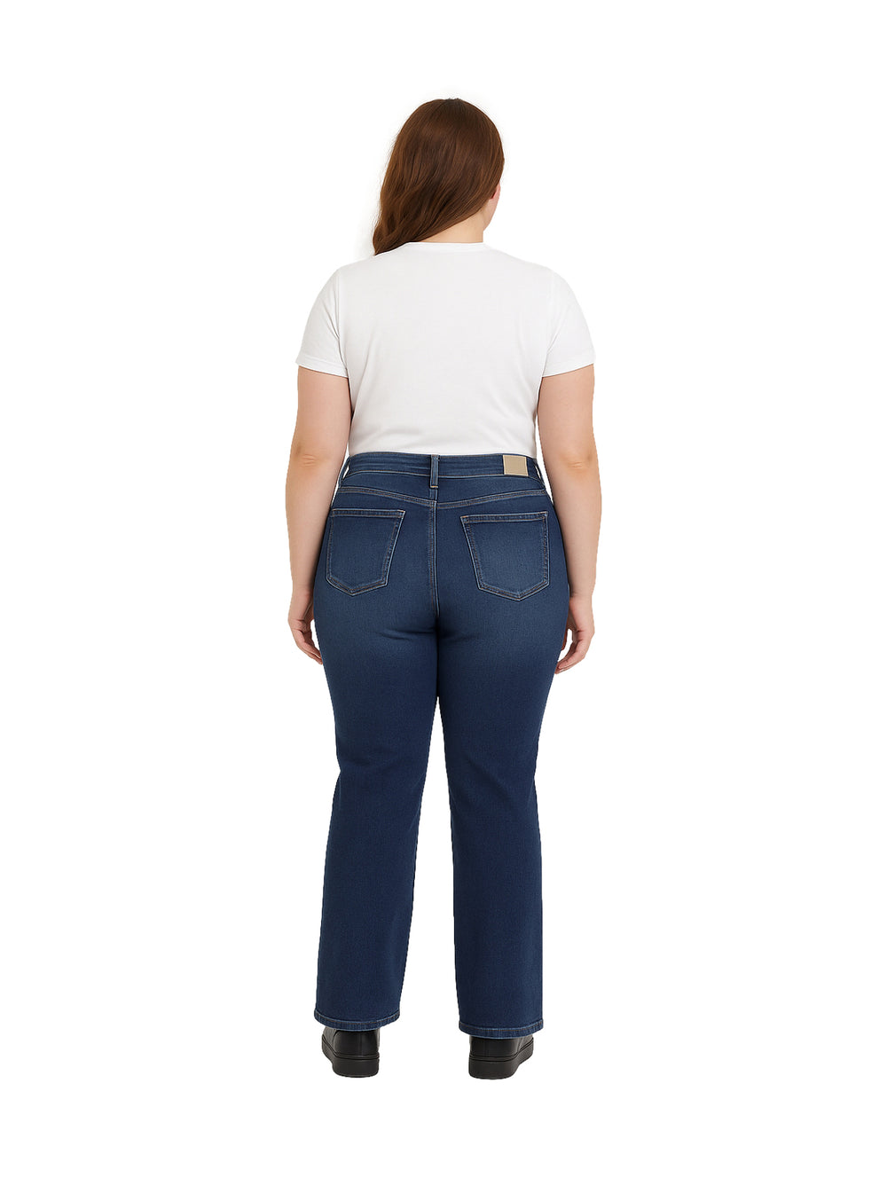 Mujer usando pantalones jeans azul oscuro de corte recto y playera blanca.