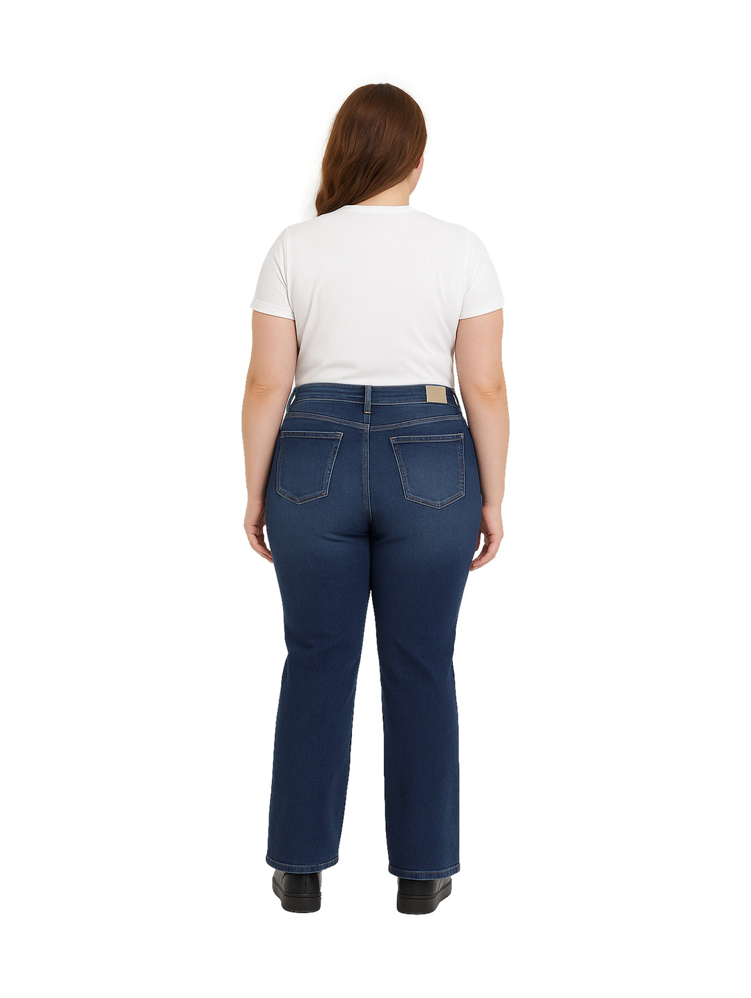 Mujer usando pantalones jeans azul oscuro de corte recto y playera blanca.