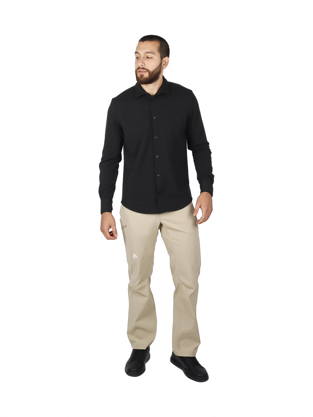 Hombre vistiendo una camisa negra de manga larga con botones y pantalones beige.