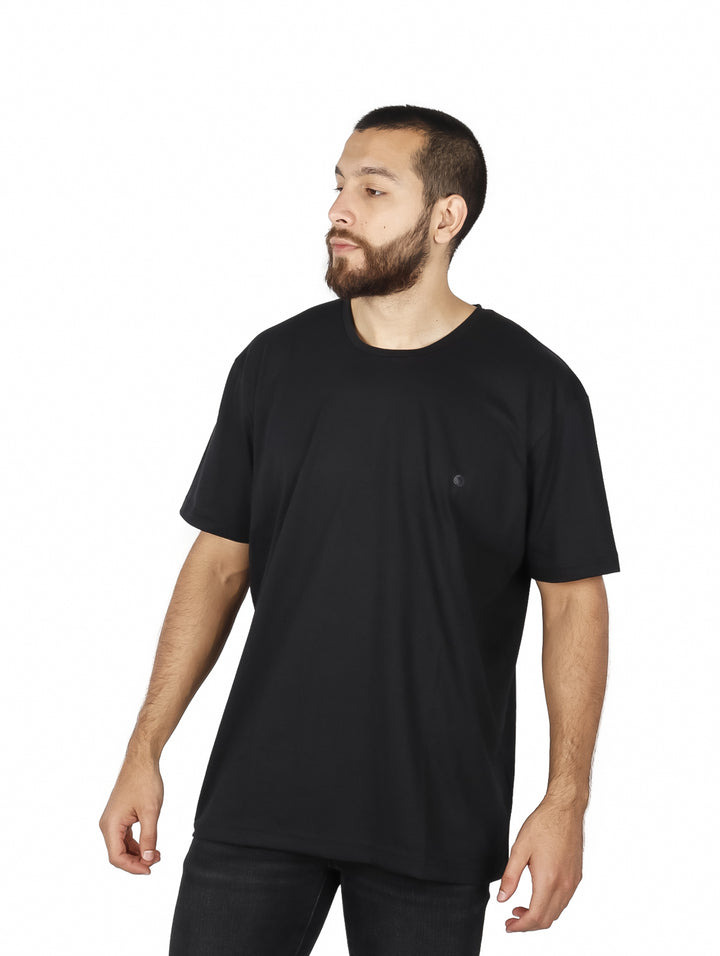 Hombre vistiendo una playera básica de color negro con cuello redondo y manga corta.