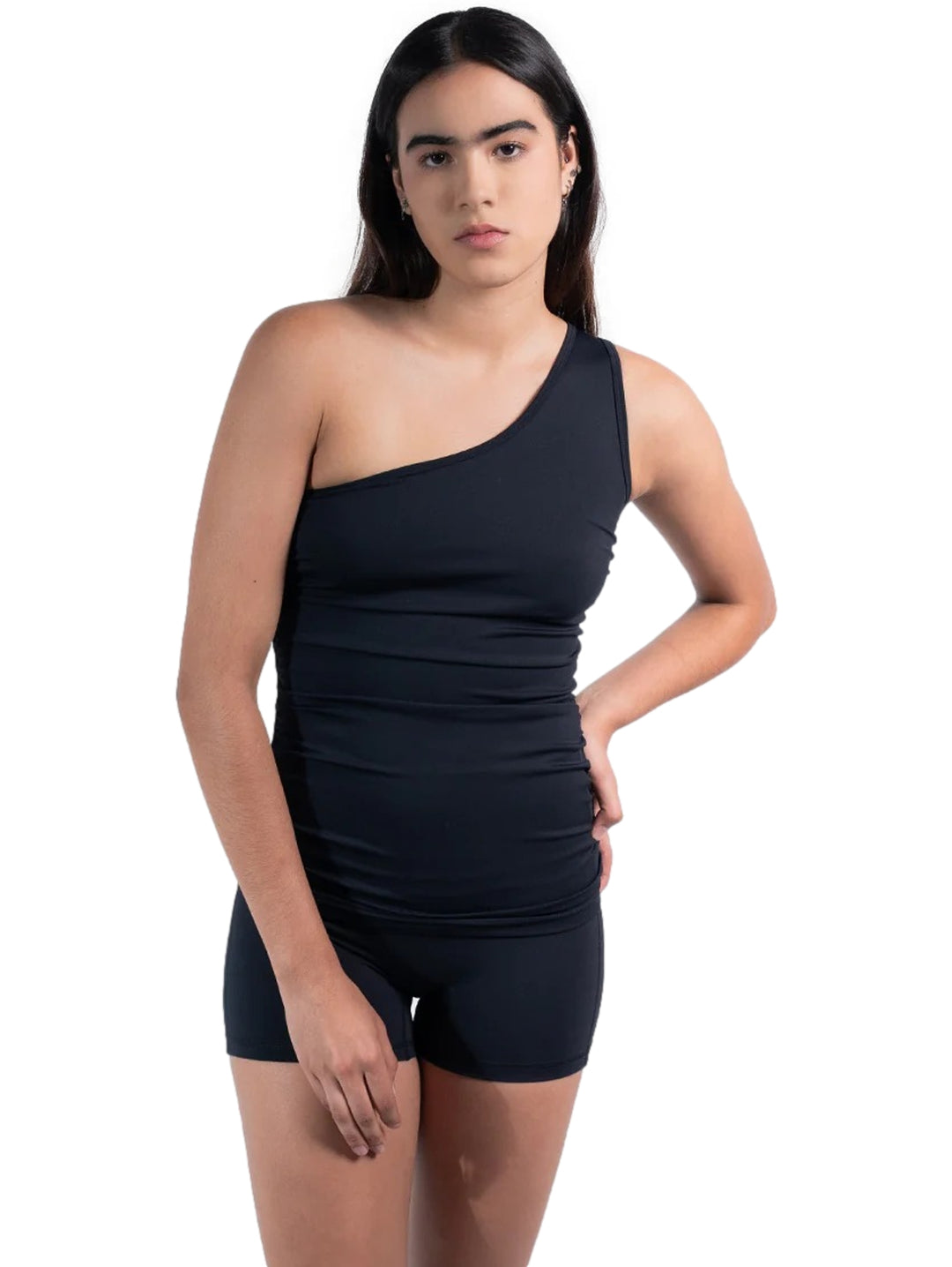Mujer vistiendo playera deportiva negra de un solo hombro y shorts a juego.