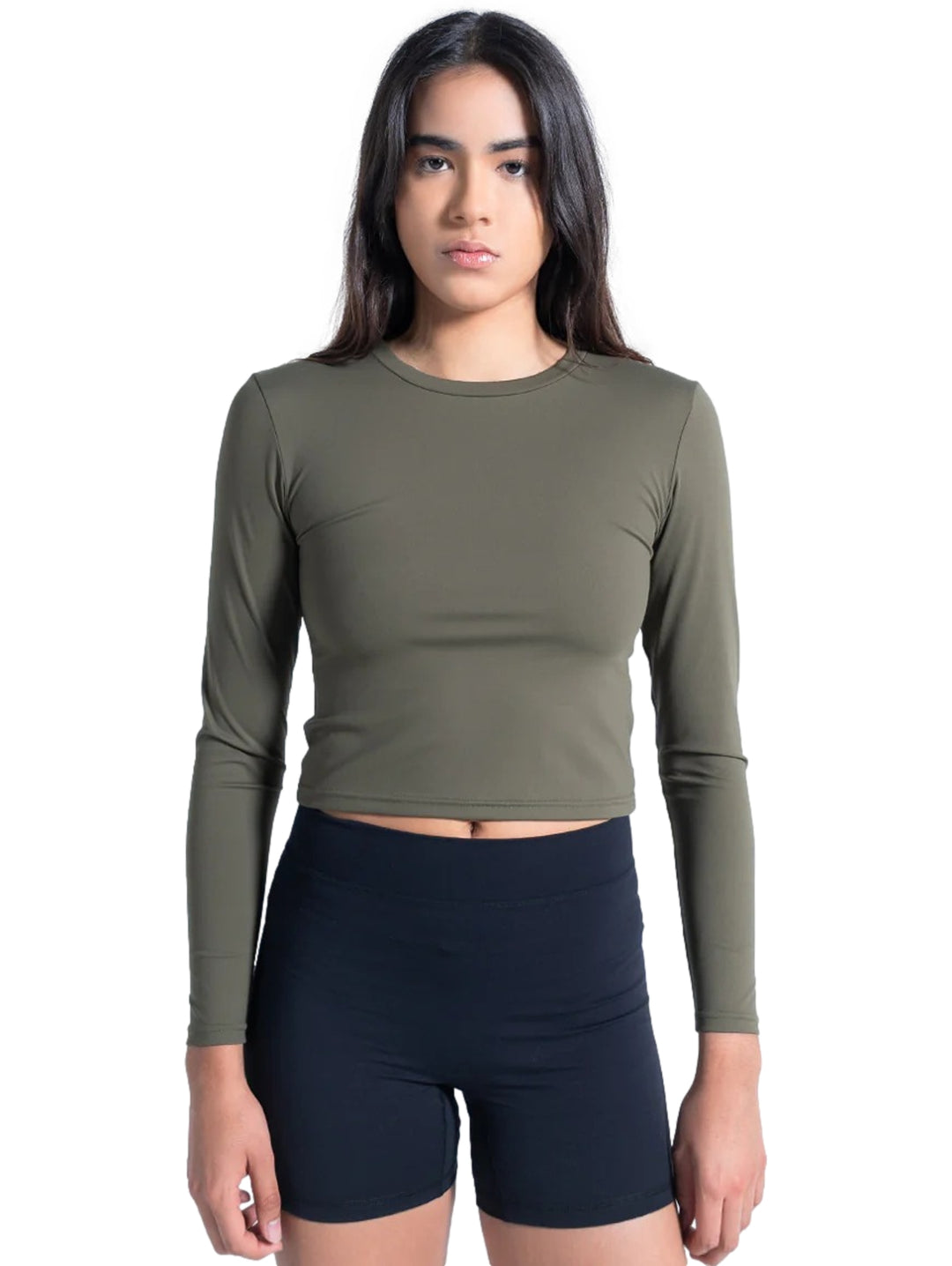 Mujer vistiendo playera deportiva manga larga color olivo de corte corto y shorts negros.