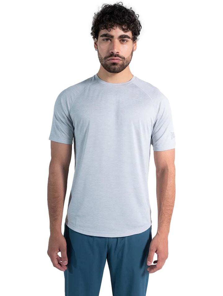 Hombre vistiendo una playera deportiva de color gris claro de manga corta y cuello redondo.