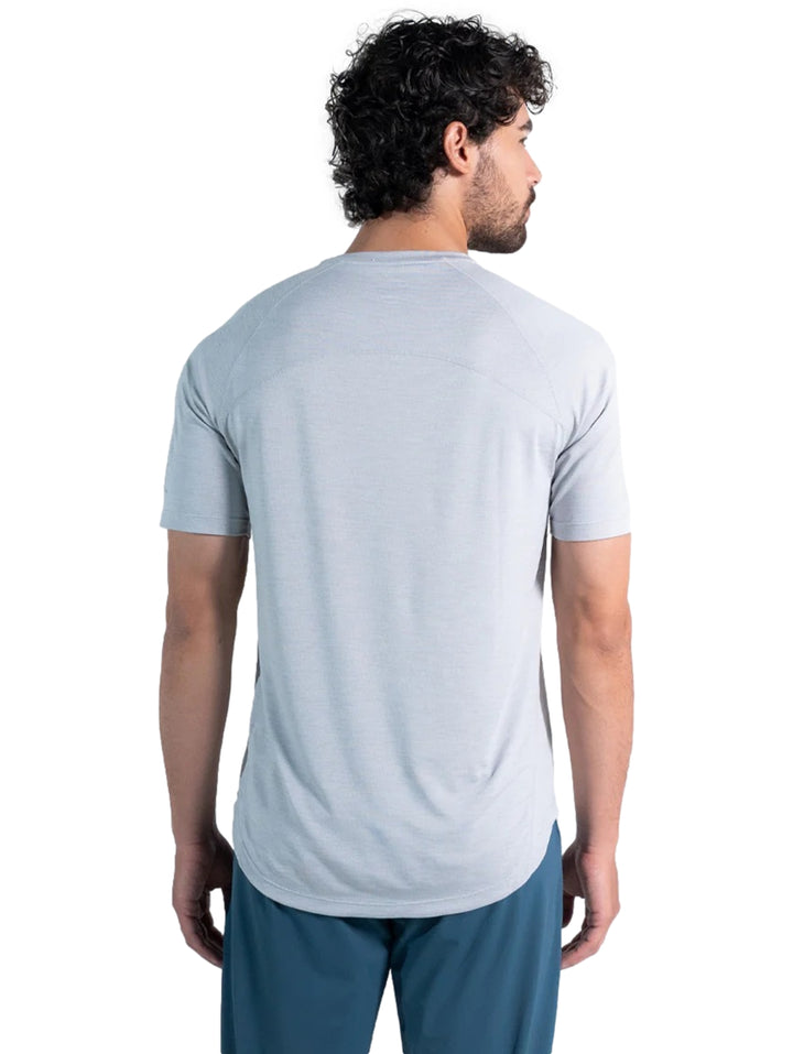 Hombre vistiendo una playera deportiva de color gris claro de manga corta y cuello redondo.