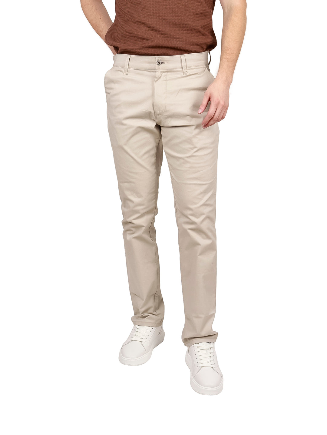 Hombre vistiendo pantalones LEE color beige de corte slim fit y tenis blancos.