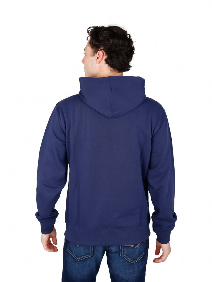 Hombre vistiendo una sudadera con capucha color azul marino con el logo de Champion en el pecho.