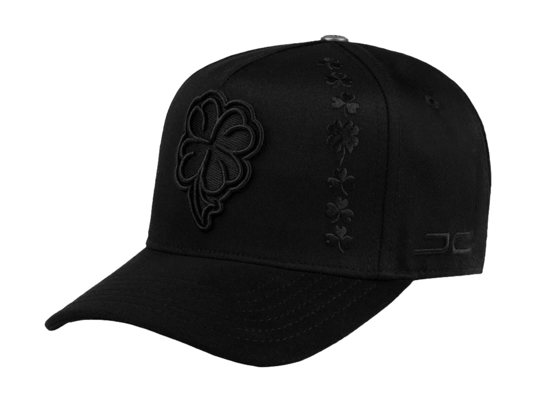 Gorra snapback color negro con bordado de trébol en relieve en el frente y lateral.