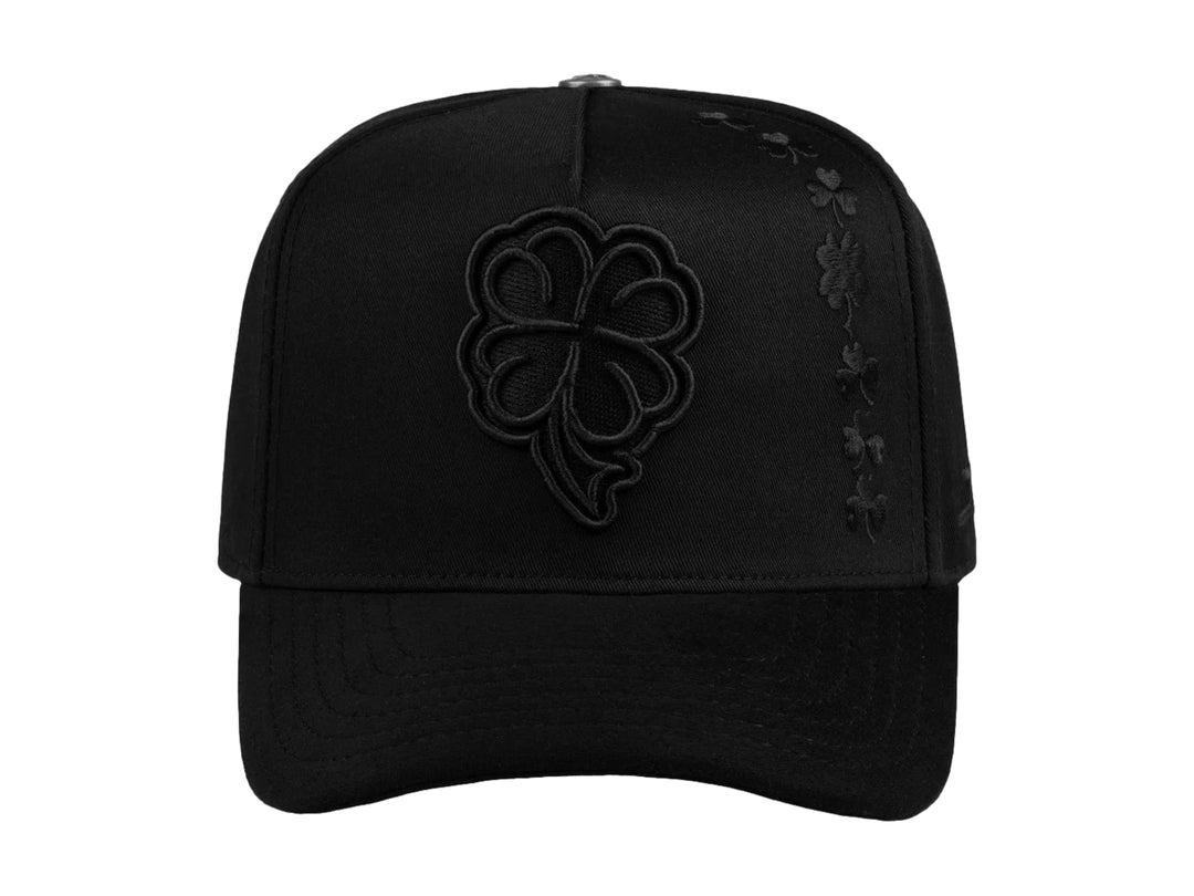 Gorra snapback color negro con bordado de trébol en relieve en el frente y lateral.