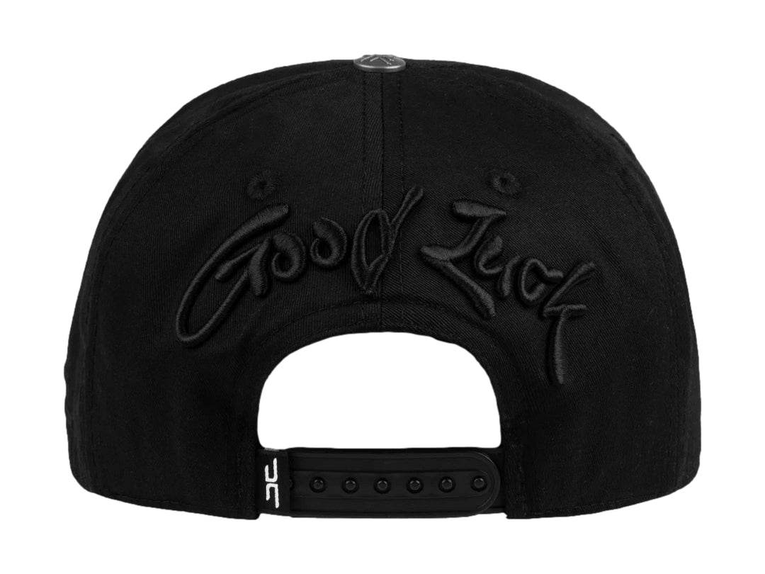 Gorra snapback color negro con bordado de trébol en relieve en el frente y lateral.