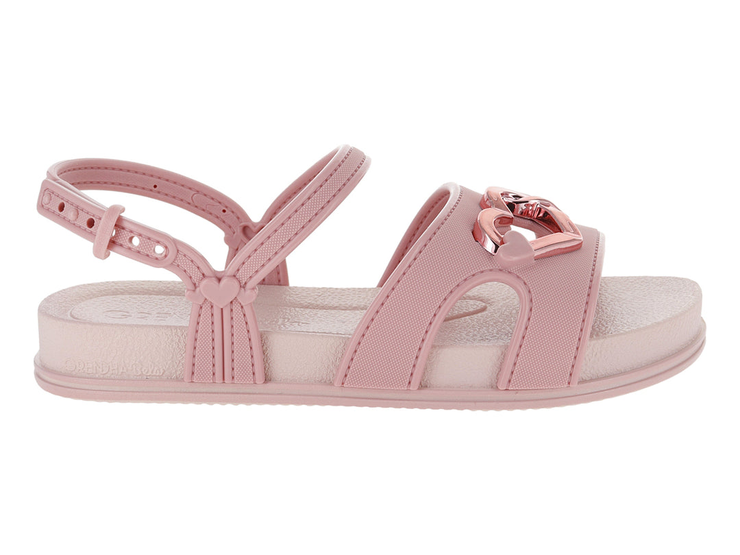 Sandalia plana de color rosa con detalle de corazón metálico y correa ajustable al tobillo.