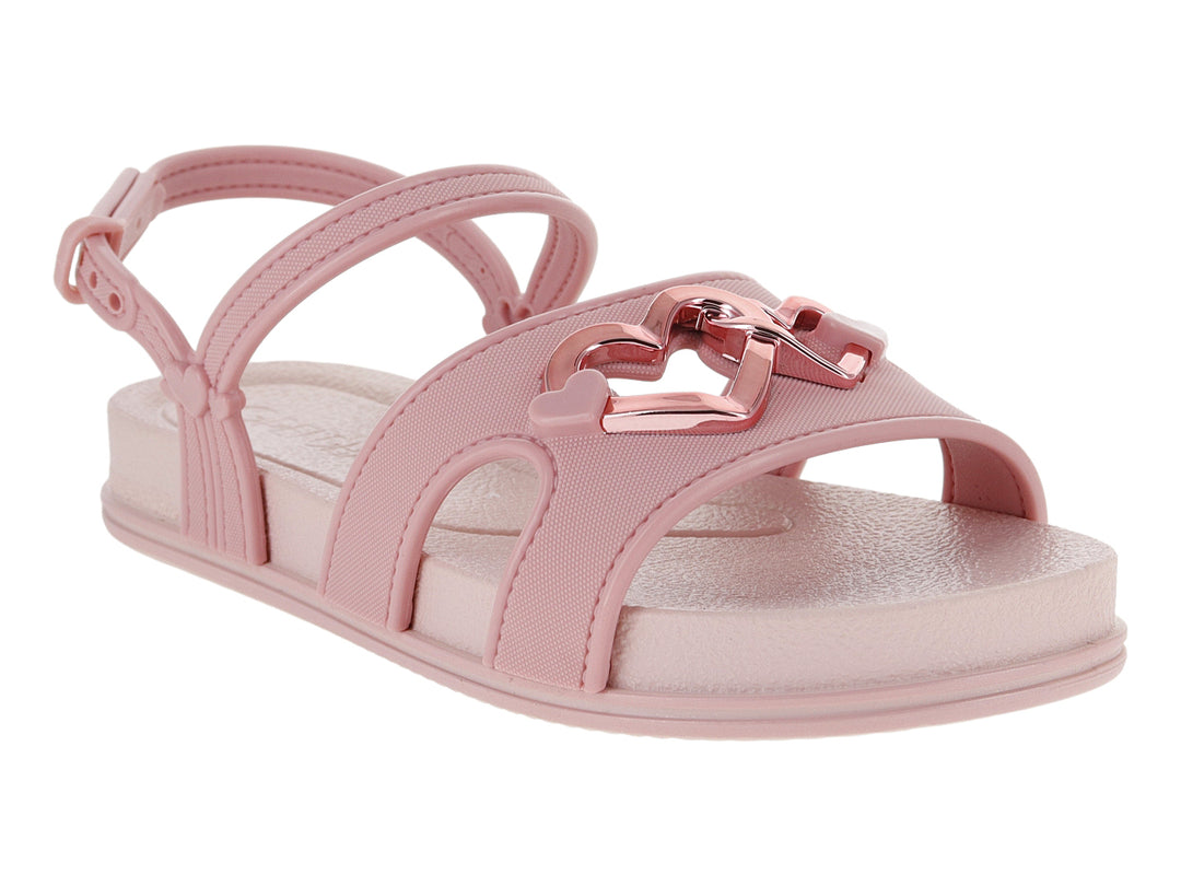 Sandalia plana de color rosa con detalle de corazón metálico y correa ajustable al tobillo.