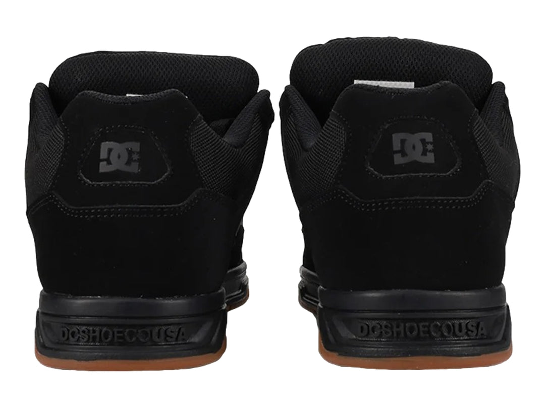 Tenis DC Shoes modelo Coiler en color negro con suela de goma marrón.