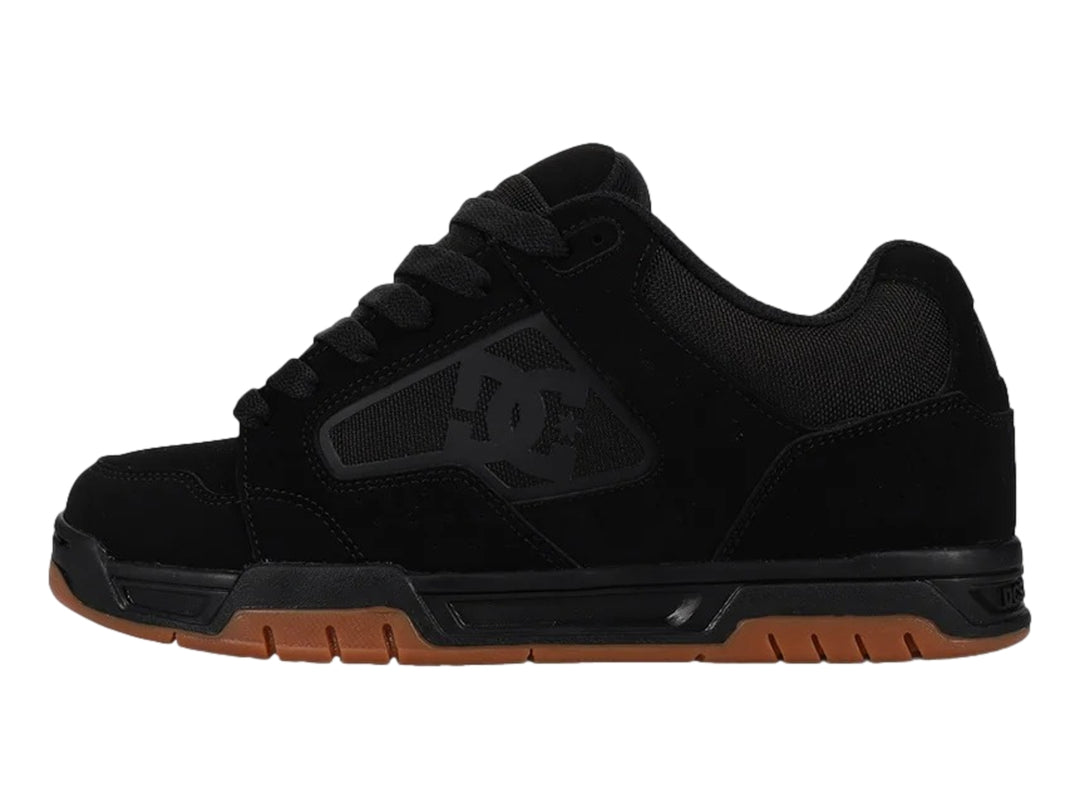 Tenis DC Shoes modelo Coiler en color negro con suela de goma marrón.