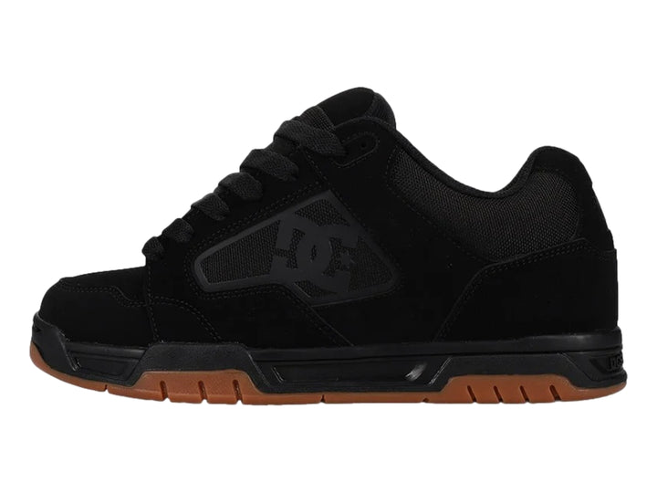 Tenis DC Shoes modelo Coiler en color negro con suela de goma marrón.