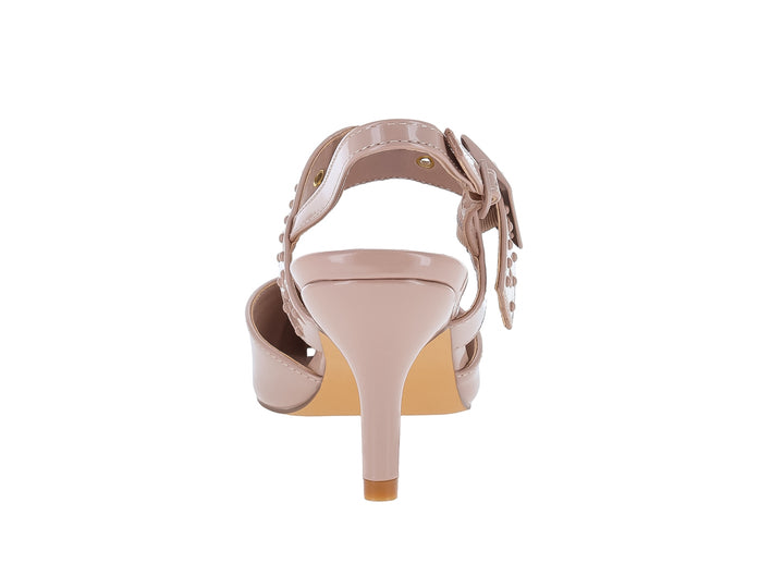 Zapato de tacón beige en acabado charol brillante con punta cerrada y correa ajustable decorada con tachuelas.