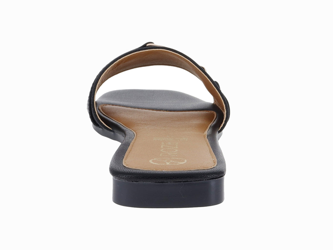 Sandalia plana color negro para mujer con hebilla decorativa dorada.
