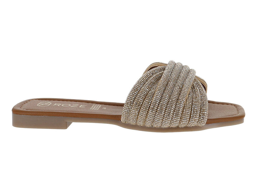 Sandalia plana color oro para niña con tira frontal trenzada y detalles brillantes.