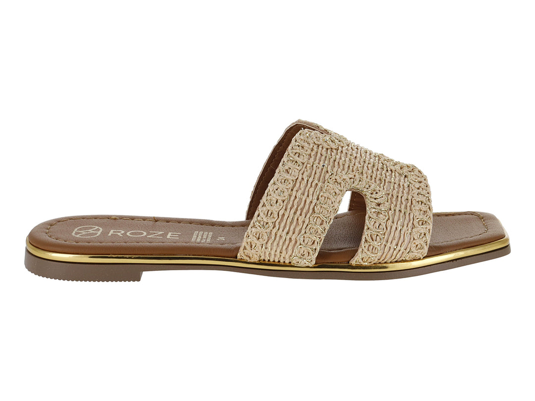Sandalia plana color beige con correa tejida y suela marrón con detalle dorado.