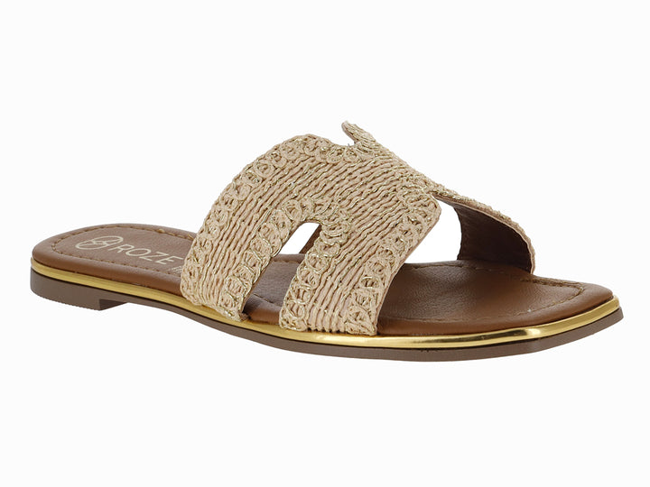 Sandalia plana color beige con correa tejida y suela marrón con detalle dorado.