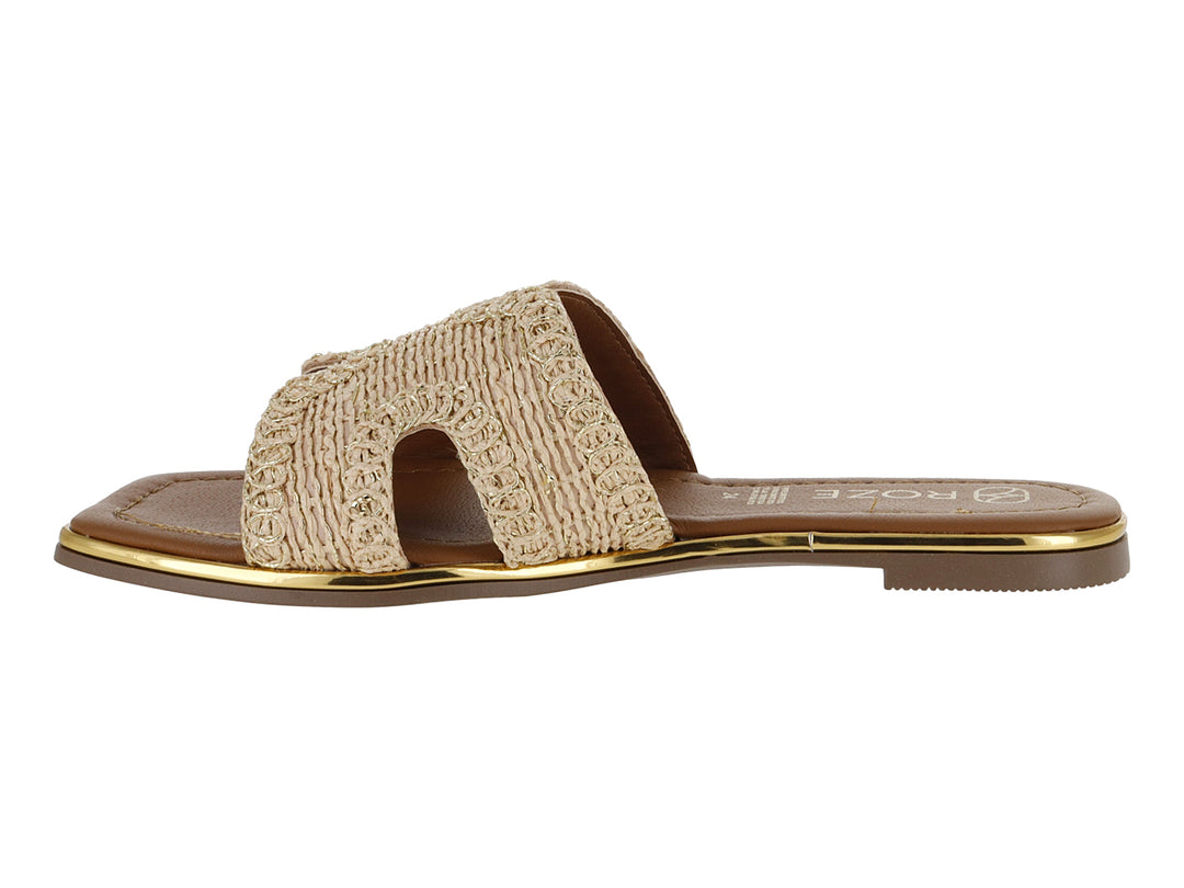 Sandalia plana color beige con correa tejida y suela marrón con detalle dorado.