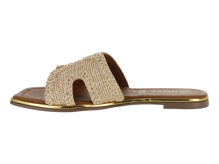 Sandalia plana color beige con correa tejida y suela marrón con detalle dorado.