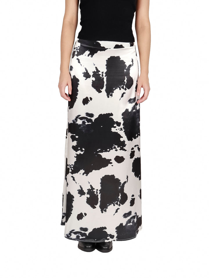 Falda larga satinada con estampado de vaca en colores blanco y negro.