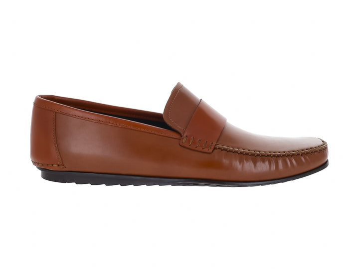 Zapato tipo mocasín de cuero color miel con suela negra para hombre.