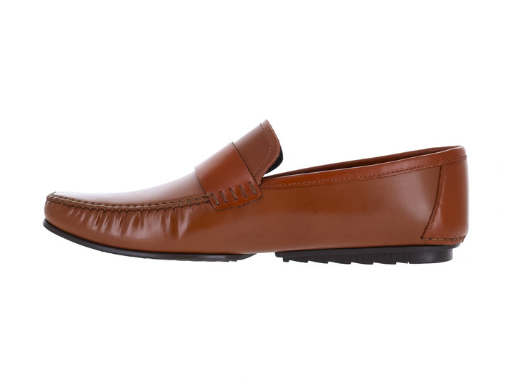 Zapato tipo mocasín de cuero color miel con suela negra para hombre.