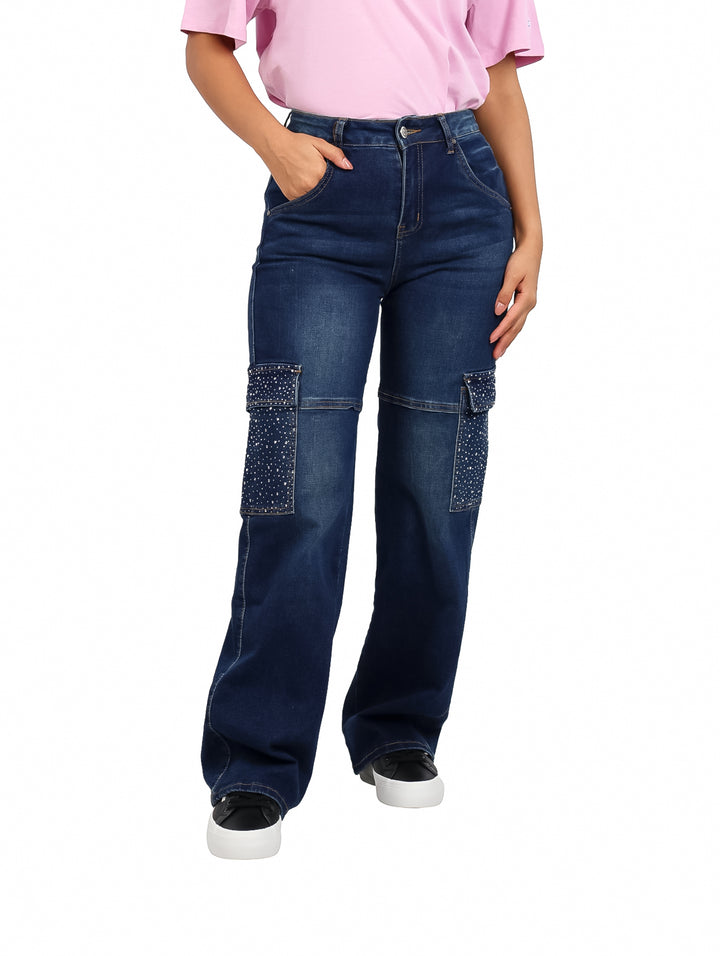 Pantalón ancho de mezclilla azul oscuro con aplicaciones de piedras brillantes en los bolsillos laterales.