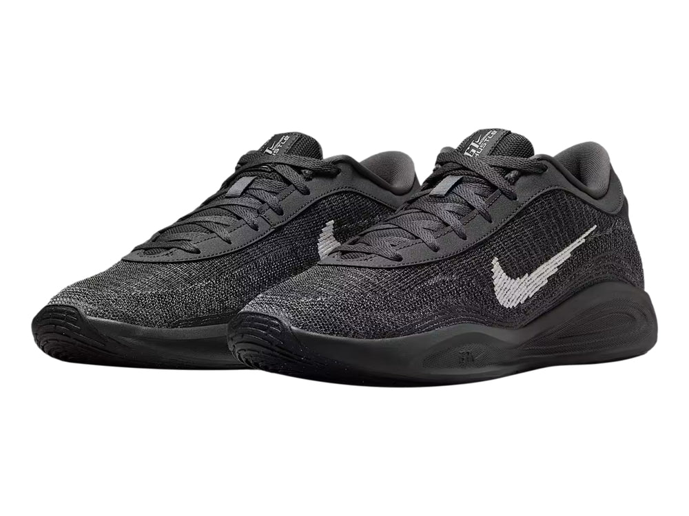 Tenis de baloncesto Nike GT Hustle Academy en color gris oscuro y negro con el logotipo de Nike en blanco.