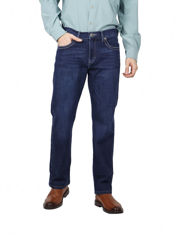 Hombre vistiendo pantalones jeans Wrangler color indigo en corte slim straight.
